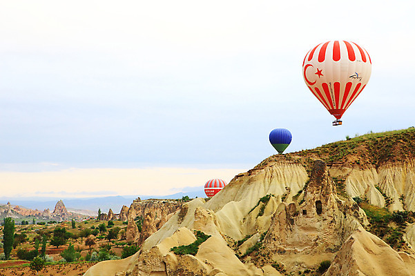 포토 JPG 주간 나무 식물 구름 해외풍경 해외 여행 중동 자연 하늘 레저 바위산 산 카파도키아 풍경 초원 사람없음 야외 레포츠 골짜기 암석 바위 열기구 비행 동굴 기암괴석 애드벌룬 동굴집 풍선 튀르키예 국내포토 자연요소 나라 아시아 항공교통 돌 바위_돌 돌산 생태계 파일형식