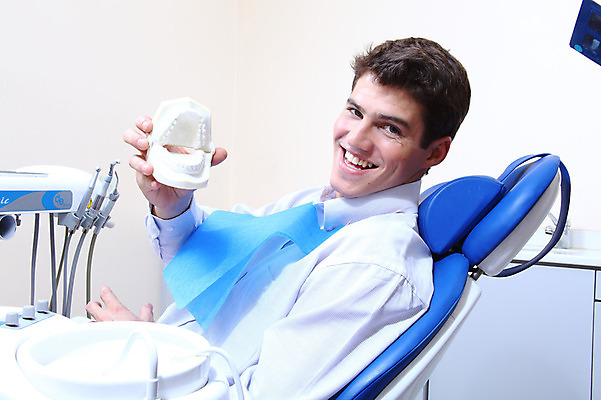 포토 JPG 서양인 외국인 남자 신체 의학 실내 치과 병원 한명 미소 웃음 들기 사람 앉기 치료 모형 환자 의료용품 치과용품 유니트체어 치아모형 덴티폼 남자만 남자한명만 국내포토 1 의자 의료기기 모션 표정 인종 내부 치아 파일형식