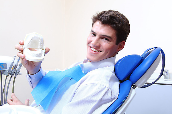 포토 JPG 서양인 외국인 남자 신체 의학 실내 치과 병원 한명 미소 웃음 들기 사람 앉기 치료 모형 환자 의료용품 치과용품 유니트체어 치아모형 덴티폼 남자만 남자한명만 국내포토 1 의자 의료기기 모션 표정 인종 내부 치아 파일형식