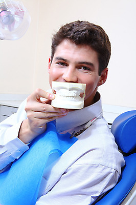 포토 JPG 서양인 외국인 남자 신체 의학 실내 치과 병원 한명 미소 웃음 들기 사람 앉기 치료 모형 환자 의료용품 치과용품 유니트체어 치아모형 덴티폼 남자만 남자한명만 국내포토 1 의자 의료기기 모션 표정 인종 내부 치아 파일형식