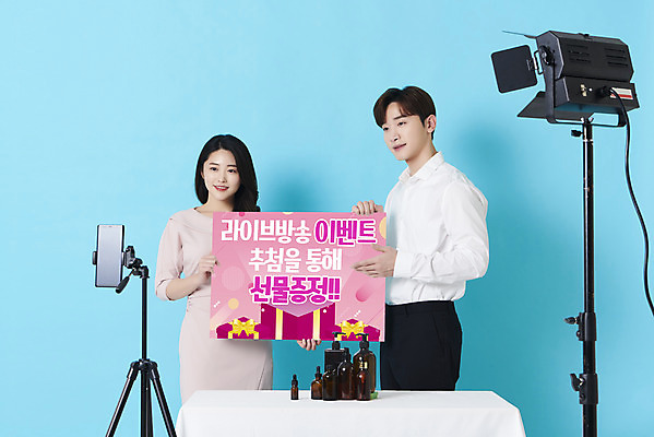 포토 JPG 스튜디오촬영 배너 응시 여자 남자 조명 사각프레임 실내 미소 들기 이벤트 상반신 20대 성인 두명 앞모습 30대 스마트폰 화장품 한국인 파란배경 방송 삼각대 선물증정 쇼호스트 성인만 유튜버 스트리밍 비대면서비스 라이브커머스 국내포토 직업 시선 뷰포인트 백그라운드 모션 프레임 표정 사람 동양인 청년 내부 장년 파란색 핸드폰 스마트기기 뷰티 사각형 서비스 모바일쇼핑 증정 파일형식 크리에이터 언택트