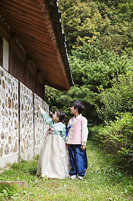 포토 JPG 주간 전신 나무 식물 여자 명절 남자 어린이 한옥 서기 사람 동양인 손짓 소녀 소년 초원 야외 두명 유치원생 한국인 가리킴 한복 어린이만 국내포토 자연요소 한국전통 전통 기념일 고건축 모션 인종 전통의상 파일형식