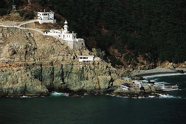 포토 JPG 주간 바다 섬 자연 산 풍경 사람없음 야외 건물 절벽 기암괴석 부산 명승지 태종대 선박 국내포토 자연요소 건축물 수상교통 한국 바위_돌 생태계 파일형식