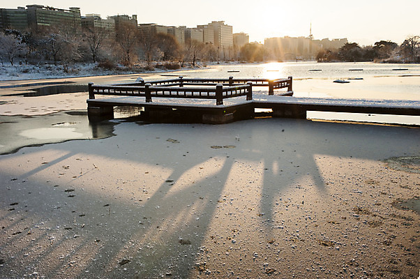 포토 JPG 주간 호수 겨울 한국 그림자 풍경 사람없음 야외 건물 햇빛 일몰 눈 나무다리 호수공원 겨울풍경 국내포토 자연요소 건축물 계절 공원 아시아 날씨 태양 노을 다리_건축물 파일형식