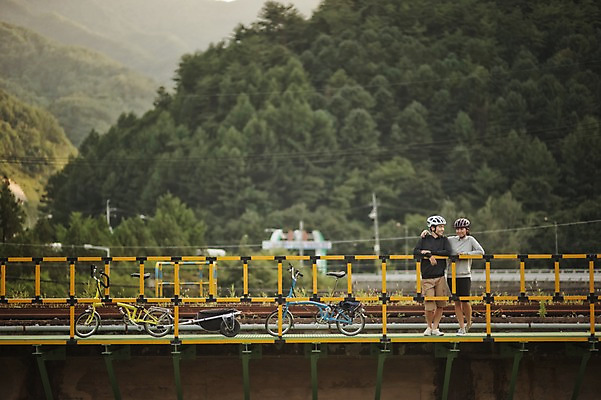 포토 JPG 주간 커플 여자 남자 여유 난간 어깨동무 휴식 서기 20대 야외 한국인 강원도 사이클링 자전거여행 라이딩 미니벨로 가교 성인만 브롬핑 국내포토 자연요소 건축물 감정 여행 포즈 컨셉 관계 모션 한국 사람 동양인 청년 자전거 캠핑 육상스포츠 파일형식