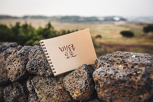 포토 JPG 주간 문자 손글씨 종이 캘리그라피 돌담 한글 사람없음 야외 아웃포커스 제주도 다이어리 방언 신천목장 맨도롱또똣 국내포토 자연요소 한국 촬영기법 담장 사무용품 목장 돌_바위 파일형식