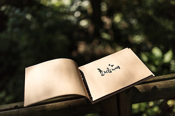 포토 JPG 주간 나무 문자 손글씨 종이 캘리그라피 한글 사람없음 야외 아웃포커스 울타리 제주도 공책 나무울타리 자연휴양림 혼저옵서예 국내포토 자연요소 식물 문구용품 한국 촬영기법 담장 방언 휴양림 파일형식