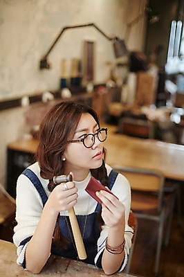 포토 JPG 응시 여자 안경 실내 한명 들기 앉기 상반신 20대 성인 앞모습 한국인 작업실 지갑 망치 가죽 가죽공예 청년여자한명만 성인여자한명만 안경낌 가죽공방 국내포토 1 시선 잡화 뷰포인트 모션 사람 동양인 청년 내부 공구 공예 여자한명만 성인여자만 청년여자만 파일형식