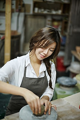 포토 JPG 여자 실내 한명 미소 앉기 상반신 20대 성인 앞치마 한국인 도자기 작업실 도자기공예 반죽 도자기물레 청년여자한명만 성인여자한명만 도자기공방 국내포토 1 모션 표정 사람 동양인 청년 내부 공예 물레 여자한명만 성인여자만 청년여자만 파일형식