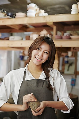 포토 JPG 여자 실내 한명 미소 들기 상반신 20대 성인 앞모습 앞치마 한국인 작업실 도자기공예 반죽 점토 청년여자한명만 성인여자한명만 도자기공방 국내포토 1 뷰포인트 모션 표정 사람 동양인 청년 내부 도자기 공예 여자한명만 성인여자만 청년여자만 파일형식