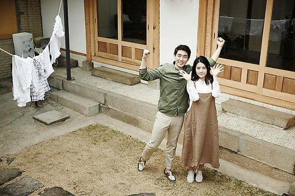 포토 JPG 주간 전신 부부 여자 남자 한옥 서기 20대 성인 야외 두명 앞모습 정원 활발 한국인 빨랫줄 즐거움 손인사 신혼집 부부라이프 성인만 국내포토 자연요소 한국전통 라이프스타일 커플 감정 줄 뷰포인트 컨셉 고건축 모션 사람 동양인 청년 인사 파일형식