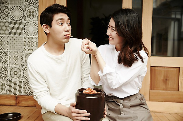 포토 JPG 주간 부부 여자 남자 김치 한옥 들기 앉기 상반신 20대 성인 야외 두명 앞모습 정원 다정 한국인 먹여주기 김장독 신혼집 부부라이프 성인만 국내포토 자연요소 한국전통 라이프스타일 커플 한식 뷰포인트 컨셉 고건축 모션 사람 동양인 청년 먹기 파일형식