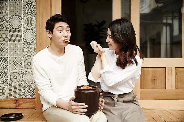 포토 JPG 주간 부부 여자 남자 김치 한옥 들기 앉기 상반신 20대 성인 야외 두명 앞모습 정원 다정 한국인 먹여주기 김장독 신혼집 부부라이프 성인만 국내포토 자연요소 한국전통 라이프스타일 커플 한식 뷰포인트 컨셉 고건축 모션 사람 동양인 청년 먹기 파일형식