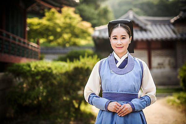 포토 JPG 주간 여자 의학 한옥 한명 서기 미소 상반신 성인 야외 앞모습 30대 한국인 간호사 한복 손모으기 의녀 성인여자만 사극 국내포토 자연요소 1 한국전통 전통 뷰포인트 고건축 모션 표정 사람 동양인 손짓 장년 의료진 전통의상 여자만 성인만 파일형식