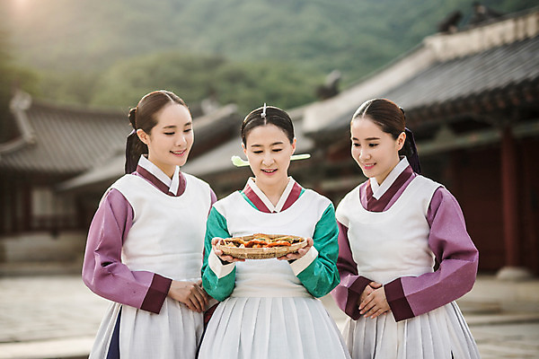 포토 JPG 주간 여자 40대 한옥 서기 미소 들기 성인 야외 앞모습 세명 30대 앞치마 한국인 한복 전 조선시대 궁녀 상궁 성인여자만 사극 국내포토 자연요소 한국전통 전통 음식 뷰포인트 중년 고건축 모션 표정 사람 동양인 장년 역사 전통의상 여자만 성인만 파일형식