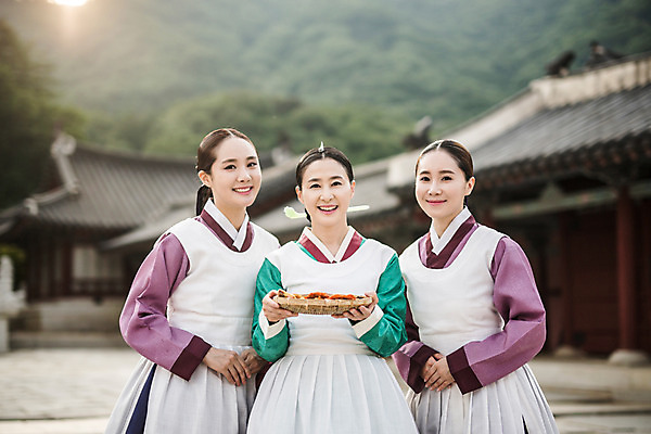 포토 JPG 주간 여자 40대 한옥 서기 미소 들기 성인 야외 앞모습 세명 30대 앞치마 한국인 한복 전 조선시대 궁녀 상궁 성인여자만 사극 국내포토 자연요소 한국전통 전통 음식 뷰포인트 중년 고건축 모션 표정 사람 동양인 장년 역사 전통의상 여자만 성인만 파일형식