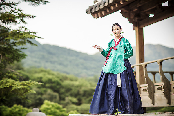 포토 JPG 주간 전신 여자 40대 한옥 안내 한명 서기 미소 손짓 성인 야외 앞모습 한국인 한복 조선시대 궁녀 상궁 성인여자만 사극 국내포토 자연요소 1 한국전통 전통 뷰포인트 중년 고건축 모션 표정 사람 동양인 역사 전통의상 여자만 성인만 파일형식