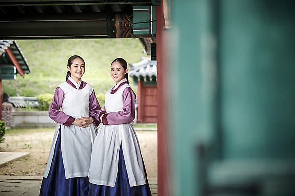 포토 JPG 주간 전신 응시 여자 한옥 서기 미소 성인 야외 두명 앞모습 30대 앞치마 한국인 한복 조선시대 손모으기 궁녀 성인여자만 사극 국내포토 자연요소 한국전통 전통 시선 뷰포인트 고건축 모션 표정 사람 동양인 손짓 장년 역사 전통의상 여자만 성인만 파일형식
