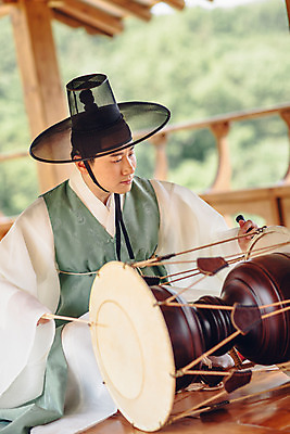 포토 JPG 주간 남자 연주 한명 앉기 성인 야외 앞모습 30대 한국인 악단 대청 한복 조선시대 장구 장구채 성인남자한명만 국내포토 갓모자 자연요소 모자_잡화 1 한국전통 음악 뷰포인트 모션 타악기 한옥 전통소품 국악기 사람 동양인 장년 역사 전통의상 남자한명만 성인남자만 파일형식