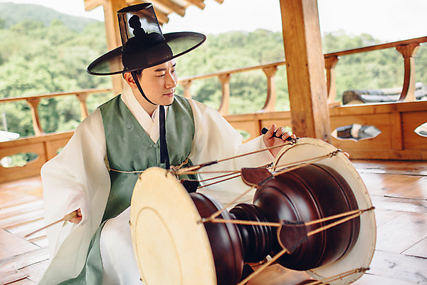 포토 JPG 주간 남자 연주 한명 앉기 성인 야외 앞모습 30대 한국인 악단 대청 한복 조선시대 장구 장구채 성인남자한명만 국내포토 갓모자 자연요소 모자_잡화 1 한국전통 음악 뷰포인트 모션 타악기 한옥 전통소품 국악기 사람 동양인 장년 역사 전통의상 남자한명만 성인남자만 파일형식