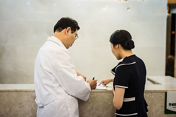 포토 직업 뷰포인트 중년 의학 모션 병원 말하기 사람 동양인 성인 내부 사무용품 의사 가운 파일형식 JPG 한의학 한의원 실내 뒷모습 대화 서기 한국인 30대 50대 상반신 두명 남자 여자 한의사 의사가운 프런트 안내원 성인만 서류판 국내포토