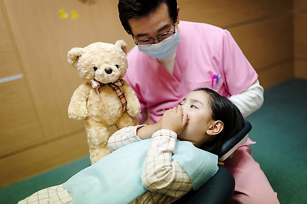 포토 JPG 여자 남자 어린이 중년 50대 의학 실내 치과 앉기 상반신 두명 앞모습 눕기 곰인형 한국인 치과의사 치과진료 국내포토 인형 뷰포인트 모션 병원 사람 동양인 성인 내부 진료 의사 파일형식 인종 의료진 직업