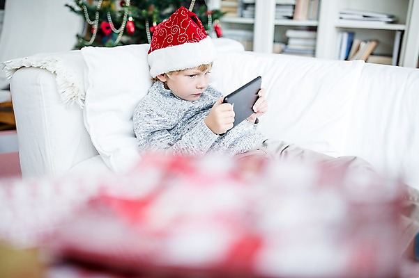 포토 JPG 서양인 외국인 남자 어린이 크리스마스 산타모자 실내 선물 한명 웃음 앉기 상반신 옆모습 아웃포커스 소파 태블릿 크리스마스트리 기쁨 국내포토 모자_잡화 1 기념일 감정 뷰포인트 의자 모션 촬영기법 표정 사람 인종 내부 전자제품 스마트기기 파일형식