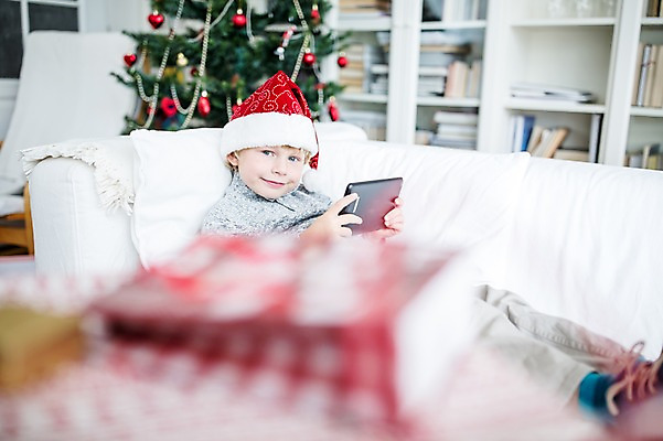포토 JPG 서양인 외국인 남자 어린이 크리스마스 산타모자 실내 선물 한명 웃음 앉기 상반신 옆모습 아웃포커스 소파 태블릿 크리스마스트리 기쁨 국내포토 모자_잡화 1 기념일 감정 뷰포인트 의자 모션 촬영기법 표정 사람 인종 내부 전자제품 스마트기기 파일형식